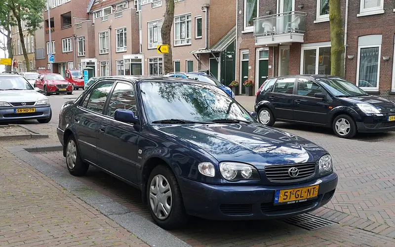 Dark blue Toyota Corolla sedan parked on a brick street
