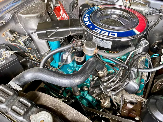 Classic V8 engine bay with blue air cleaner and fresh hoses